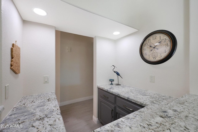 bar with light stone countertops and hardwood / wood-style floors