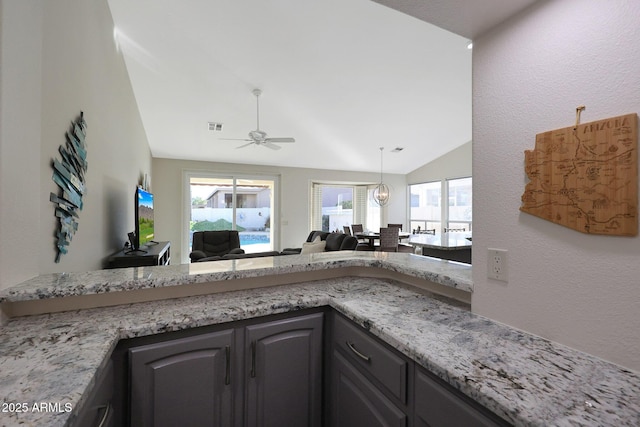 kitchen featuring ceiling fan and lofted ceiling