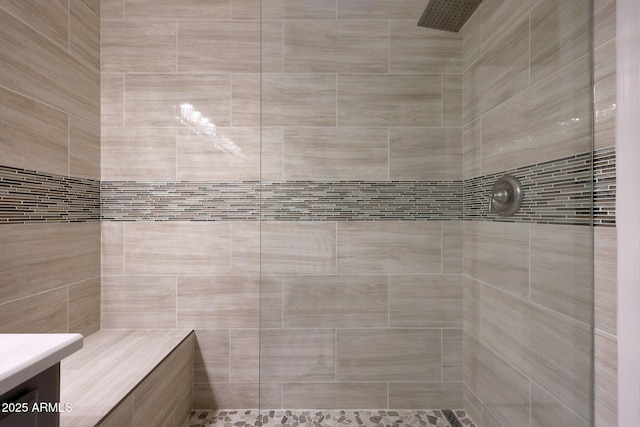 bathroom featuring tiled shower and vanity