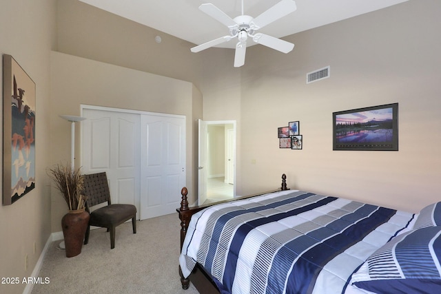 bedroom featuring light colored carpet, a closet, and ceiling fan