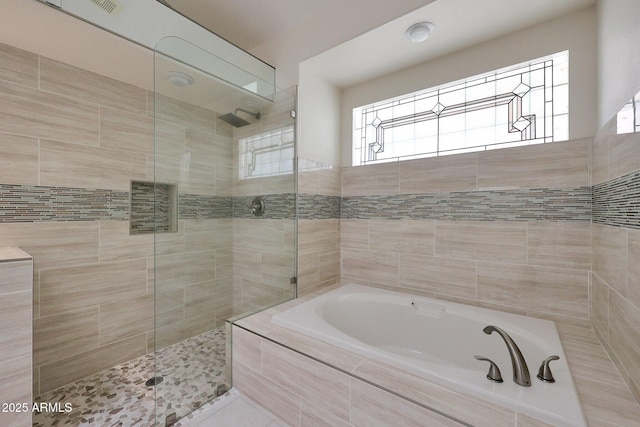 bathroom with tile patterned flooring and shower with separate bathtub