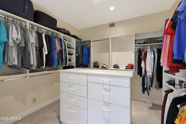 spacious closet featuring light colored carpet