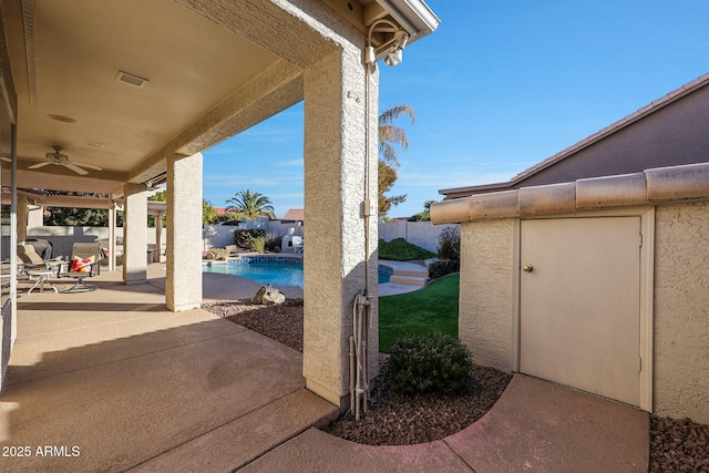 view of patio / terrace featuring a fenced in pool and ceiling fan