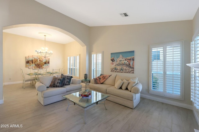 living room featuring an inviting chandelier and light wood-type flooring