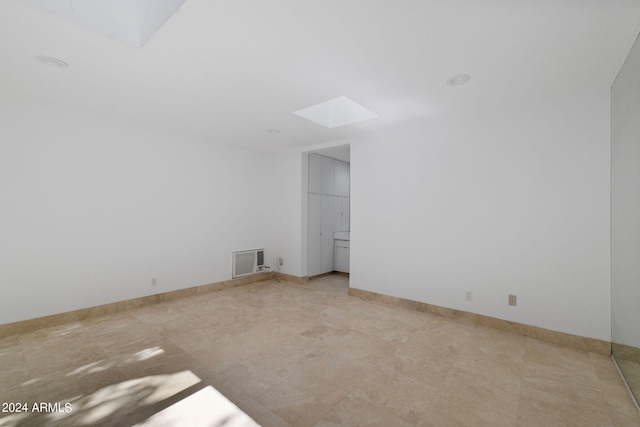 spare room featuring a skylight