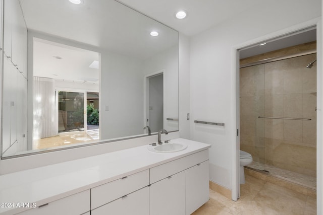 bathroom with vanity, toilet, and a shower with door