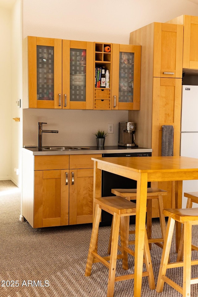 kitchen featuring white fridge, sink, and carpet