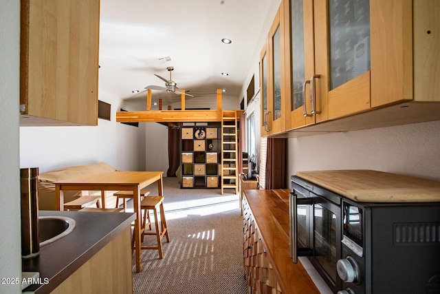 kitchen featuring lofted ceiling, carpet floors, and ceiling fan