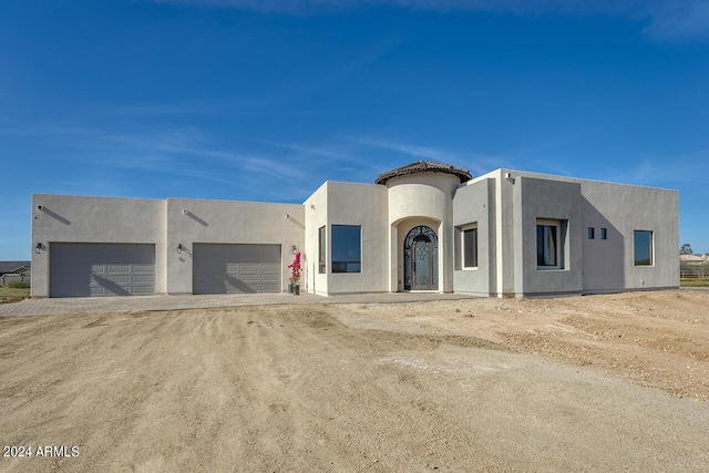 view of front of house with driveway, an attached garage, and stucco siding