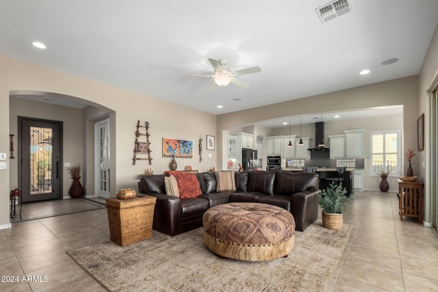 5771 W Cinder Brook Way, Florence, AZ 85132 - living room with arched walkways, light tile patterned floors, a ceiling fan, recessed lighting, and baseboards