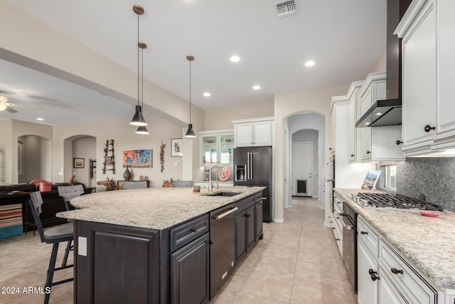 5771 W Cinder Brook Way, Florence, AZ 85132 - kitchen with a sink, stainless steel appliances, arched walkways, white cabinetry, and decorative backsplash