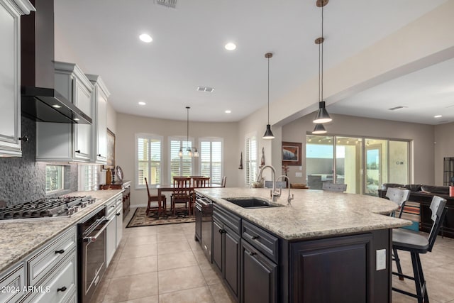 5771 W Cinder Brook Way, Florence, AZ 85132 - kitchen with a sink, wall chimney range hood, stainless steel appliances, open floor plan, and decorative backsplash