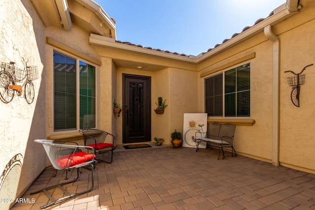5771 W Cinder Brook Way, Florence, AZ 85132 - view of exterior entry featuring a patio and stucco siding