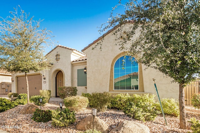 5771 W Cinder Brook Way, Florence, AZ 85132 - mediterranean / spanish-style home with stucco siding, an attached garage, and a tiled roof