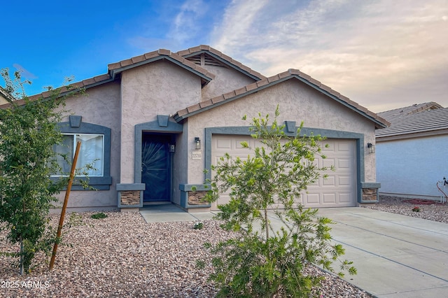 view of front facade featuring stucco siding, an attached garage, driveway, and a tile roof