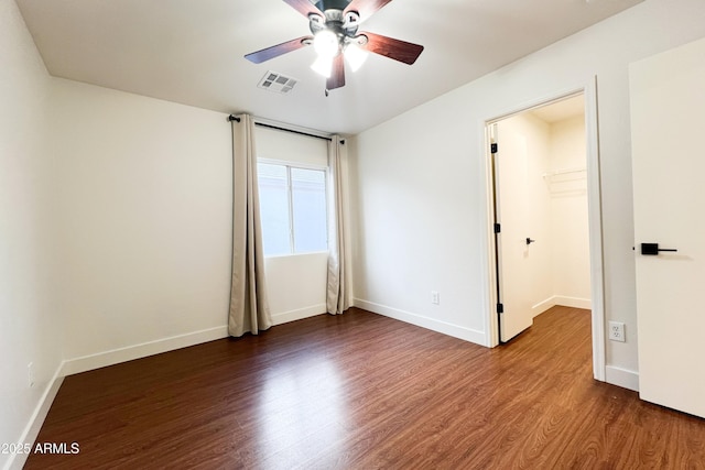 spare room with a ceiling fan, wood finished floors, and baseboards