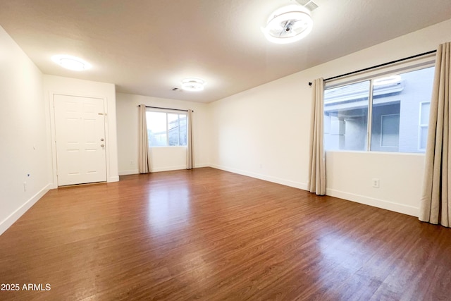 empty room featuring wood finished floors and baseboards