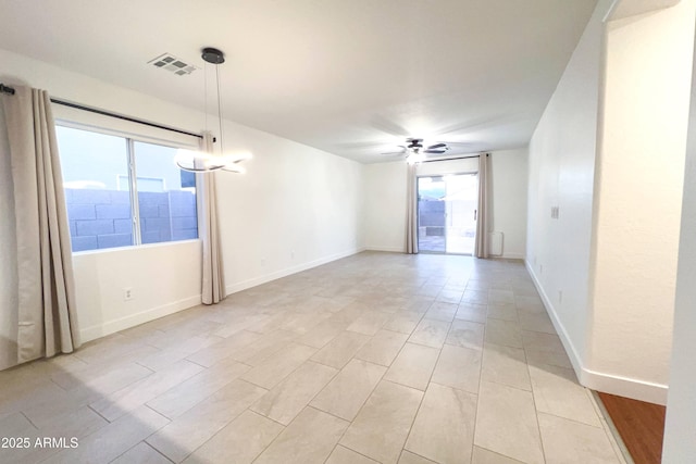 empty room with healthy amount of natural light, a ceiling fan, baseboards, and light wood finished floors