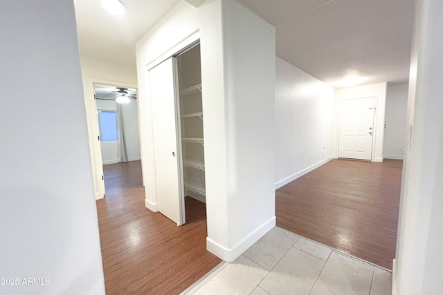 hall featuring light wood finished floors and baseboards