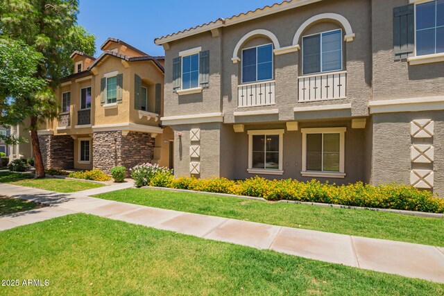 9233 E Neville Ave Unit 1127, Mesa, AZ 85209 - view of front of house featuring stucco siding, stone siding, and a front lawn