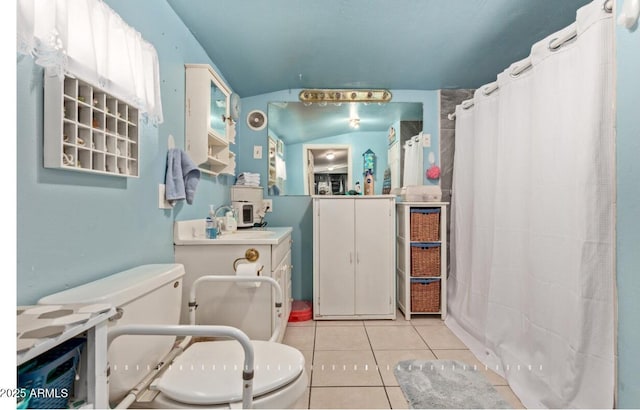 bathroom with walk in shower, toilet, sink, vaulted ceiling, and tile patterned flooring