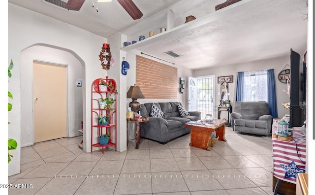 tiled living room featuring ceiling fan and a textured ceiling