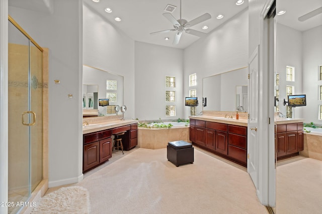 bathroom with ceiling fan, vanity, a high ceiling, and shower with separate bathtub