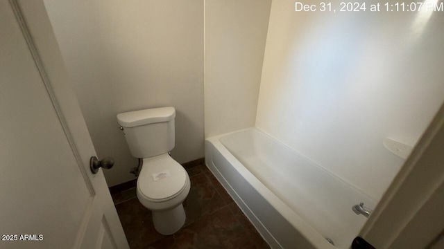 bathroom featuring toilet, a tub to relax in, and tile patterned floors