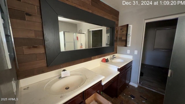 bathroom featuring a shower, a sink, and double vanity