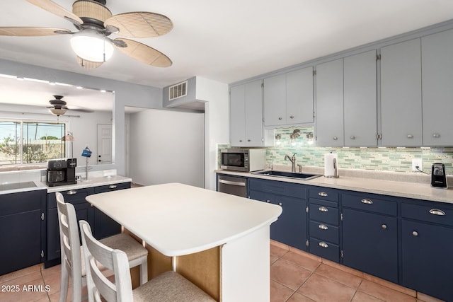 1308 N 66th St, Scottsdale, AZ 85257 - kitchen featuring ceiling fan, stainless steel appliances, light tile patterned flooring, and blue cabinets