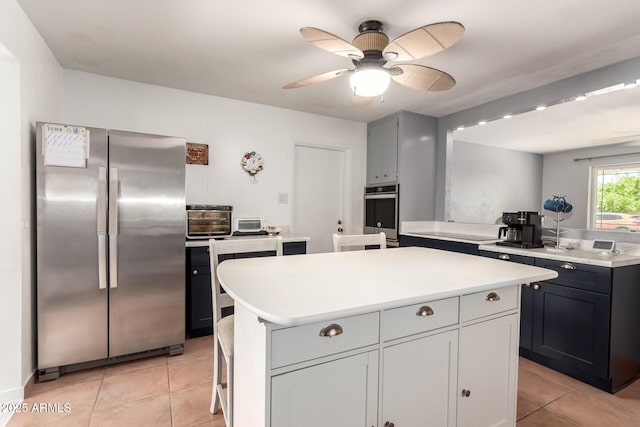 1308 N 66th St, Scottsdale, AZ 85257 - kitchen with freestanding refrigerator, light countertops, light tile patterned flooring, a center island, and a ceiling fan