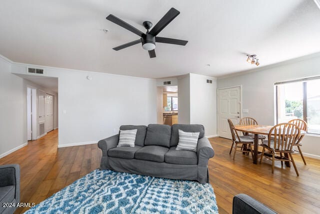 living room with ceiling fan, ornamental molding, and hardwood / wood-style floors