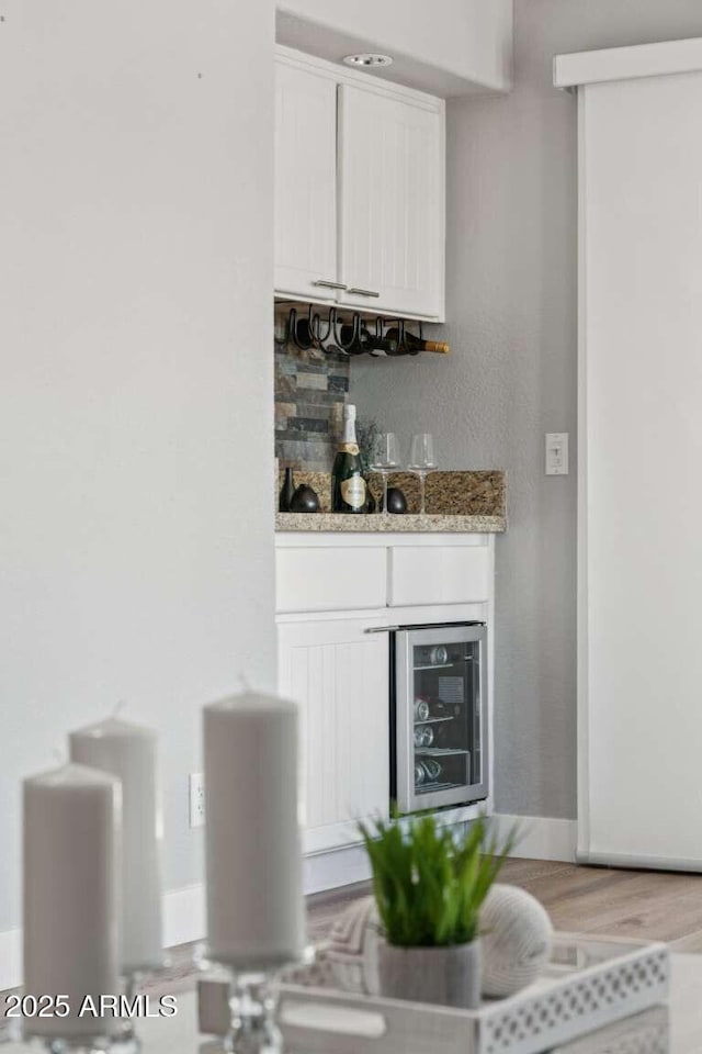 13227 N Mimosa Dr Unit 101, Fountain Hills, AZ 85268 - indoor dry bar with wine cooler, light wood-style floors, and decorative backsplash