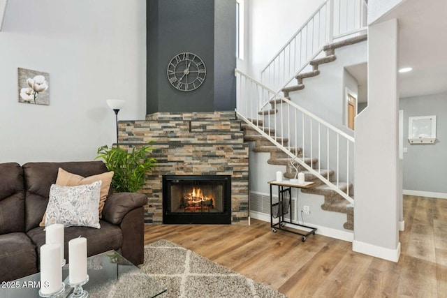 13227 N Mimosa Dr Unit 101, Fountain Hills, AZ 85268 - living area with stairway, wood finished floors, a towering ceiling, and a fireplace