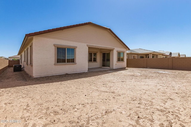 rear view of house featuring central air condition unit, a fenced backyard, and a patio area