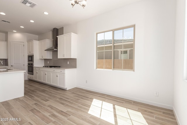 kitchen with visible vents, stainless steel appliances, wall chimney exhaust hood, and recessed lighting