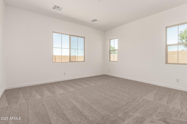 empty room with visible vents, carpet floors, and baseboards