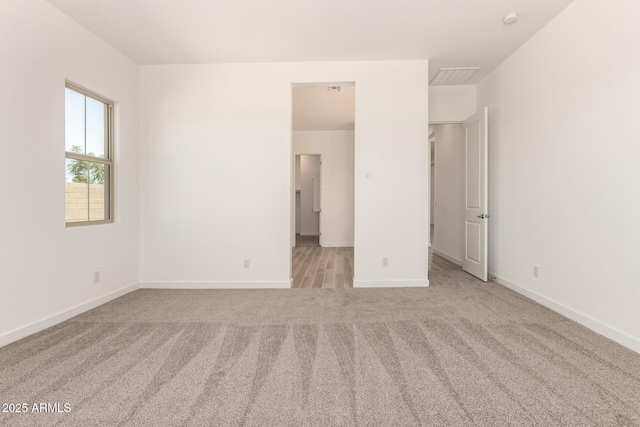 unfurnished bedroom featuring baseboards and light carpet