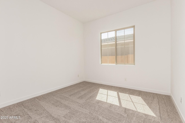 unfurnished room with carpet and baseboards