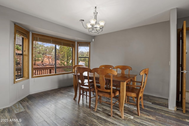 dining space with baseboards, a notable chandelier, and wood finished floors