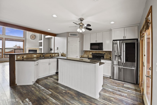 kitchen with visible vents, decorative backsplash, white cabinets, black appliances, and dark wood-style flooring