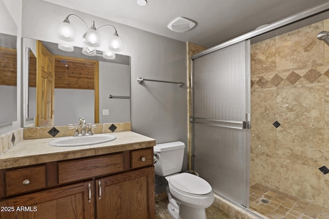 bathroom featuring vanity, toilet, and a shower stall