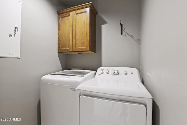 clothes washing area with cabinet space and washing machine and clothes dryer