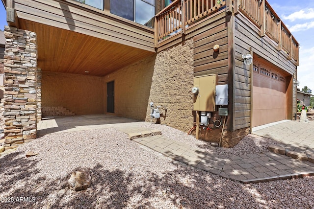 view of side of property featuring an attached garage and driveway