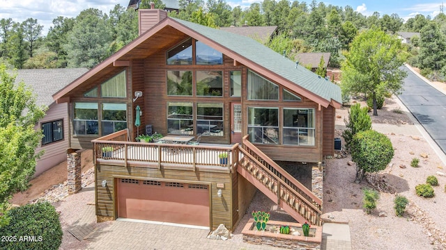 view of front of house with stairs, a garage, decorative driveway, and a chimney