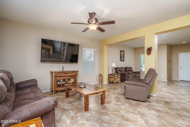 living room featuring ceiling fan and a wealth of natural light