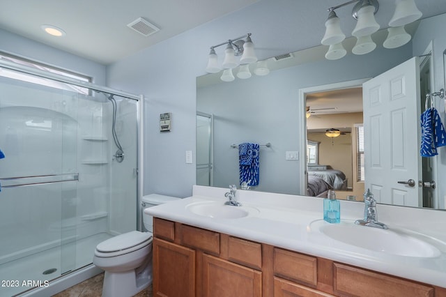 bathroom with tile patterned floors, toilet, a shower with door, and vanity