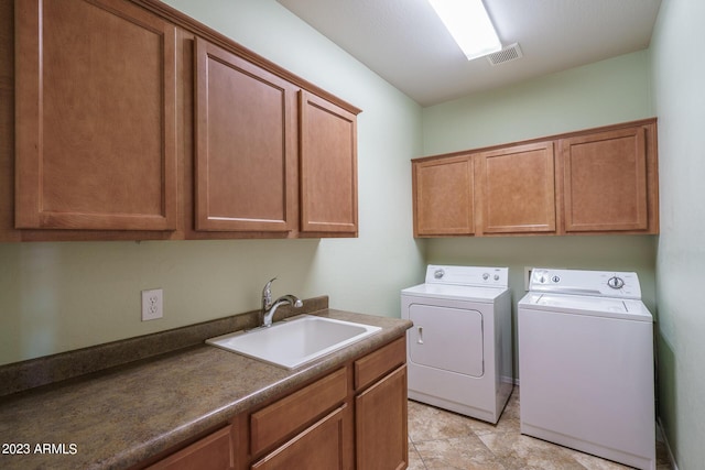 laundry area featuring cabinets, independent washer and dryer, and sink