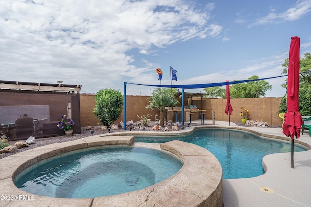 view of swimming pool with an in ground hot tub