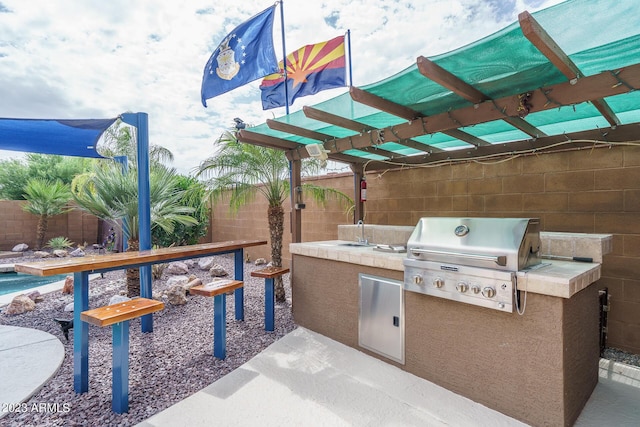 view of patio featuring an outdoor kitchen, grilling area, and sink